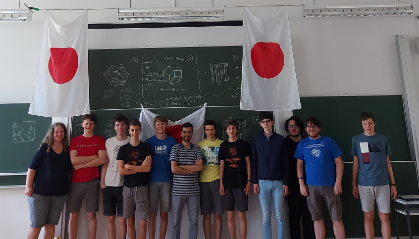 Gruppenfoto vom IMO/MEMO Training vor einer beschriebenen Tafel und zwei japanischen Flaggen 